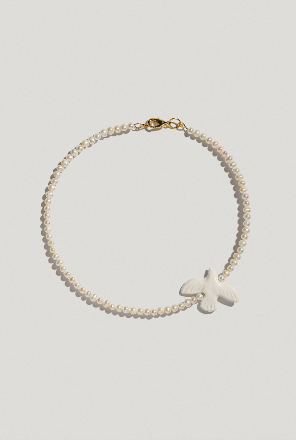 Necklace with big river pearls and a bird