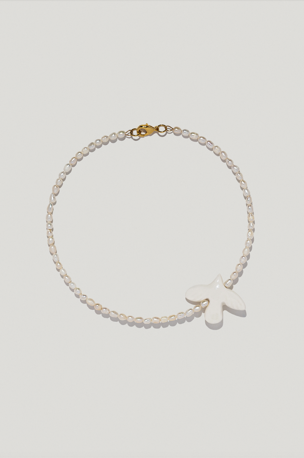 Necklace with oval river pearls and porcelain bird