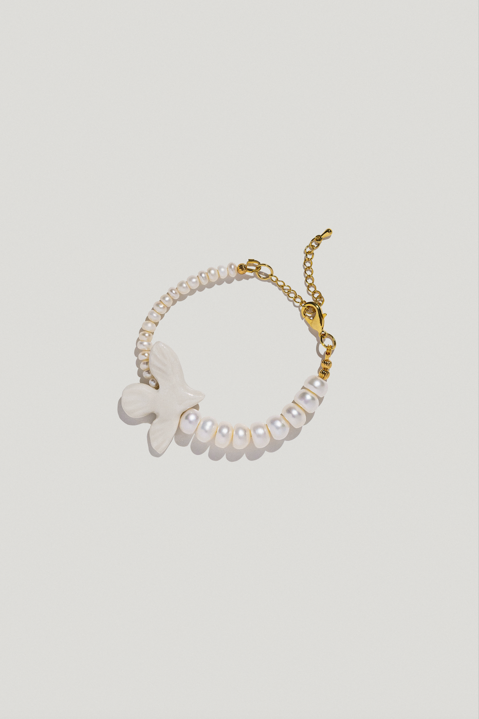 Wristband with two types of pearls and a porcelain bird