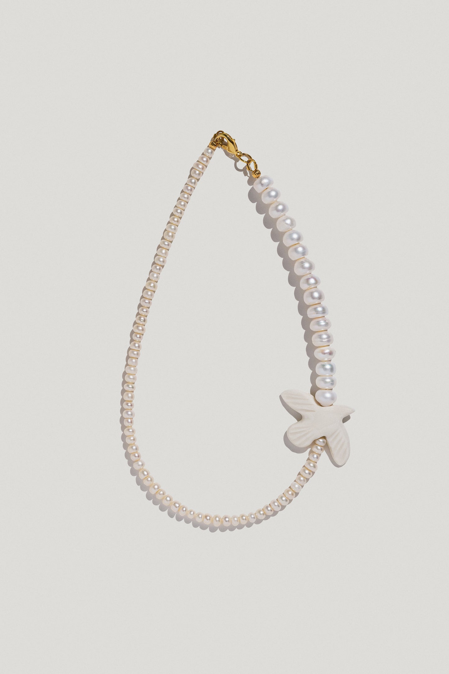 [M Y R N I]  necklace with double-sized pearls and a porcelain bird