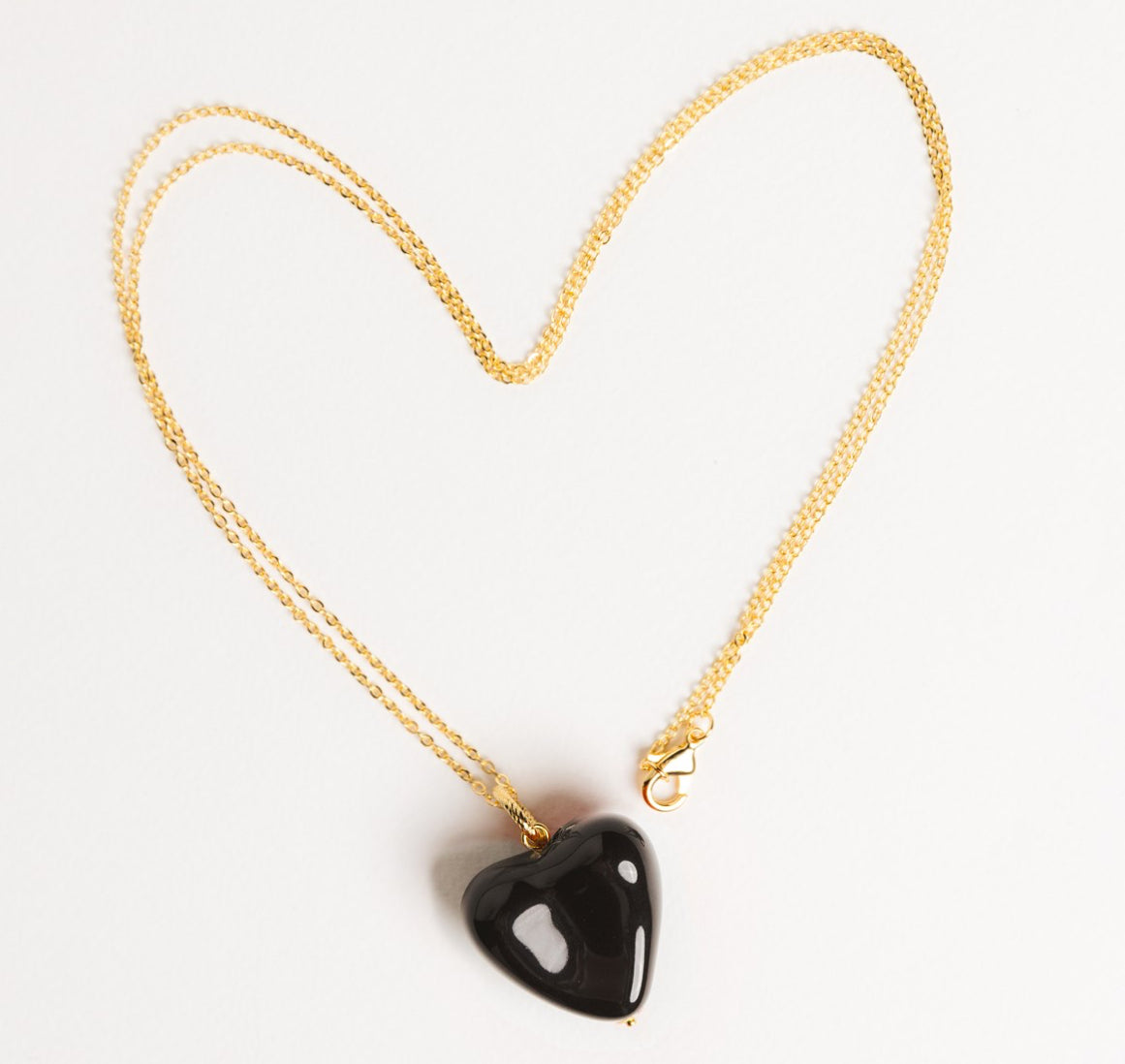 AURA pendant with a black heart on a chain